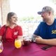 A man and woman sitting at a table at West Sandy Creek Winery enjoying WSCW wine and smiling.